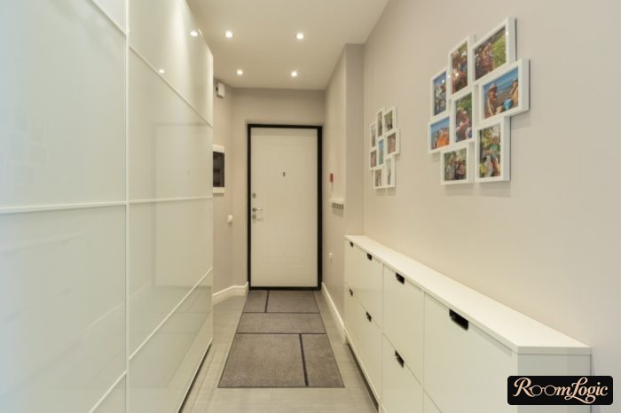 sliding-door wardrobe made of matte white glass and narrow sliding shoe rack in hallway