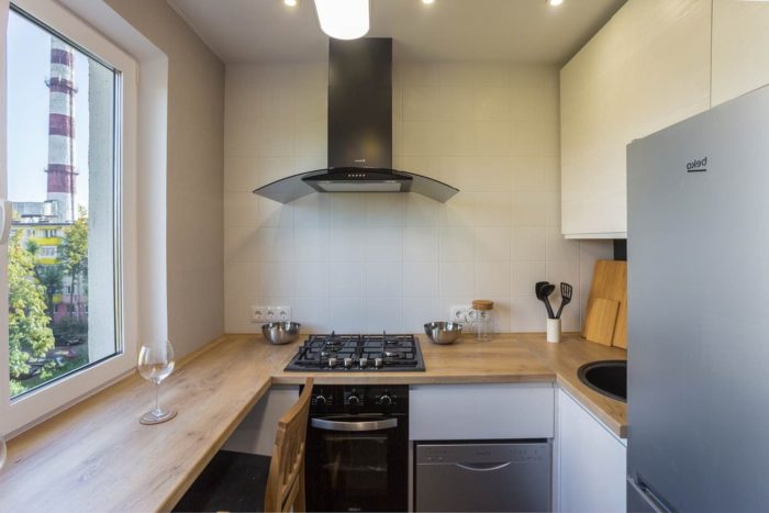 small white kitchen with wooden countertop-window sill