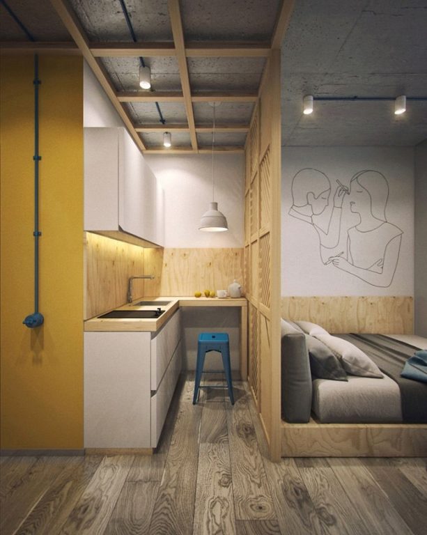 studio apartment with small kitchen and bed