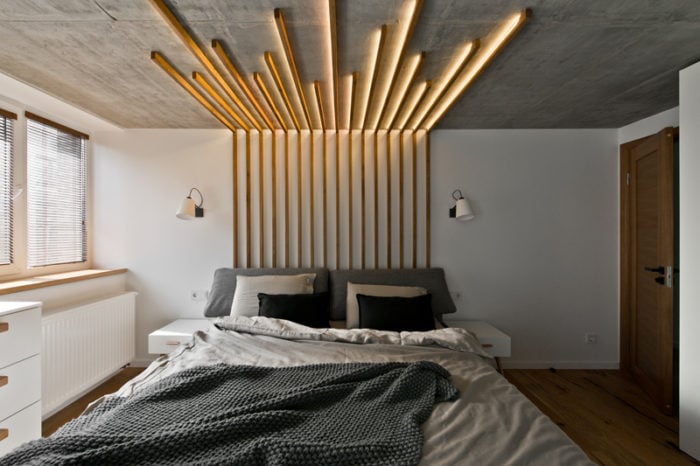 Suspended wooden planks with lighting in a modern bedroom
