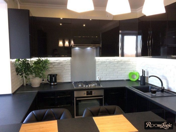 U-shaped black kitchen with dining area by the window