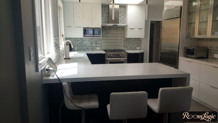 U-shaped kitchen by the window with a breakfast bar