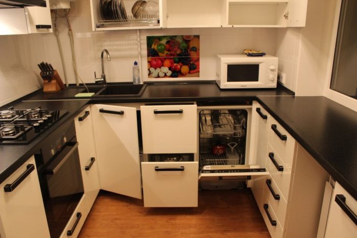 U-shaped kitchen in a tiny apartment with window sill as countertop