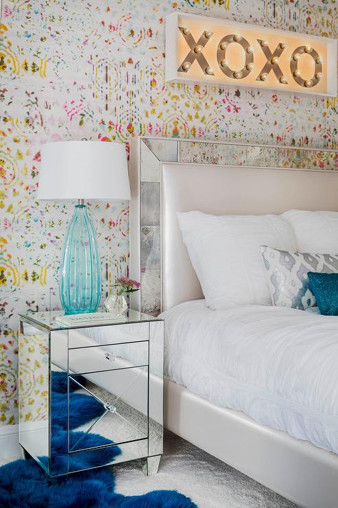 wallpaper with multicolored spots behind the bed