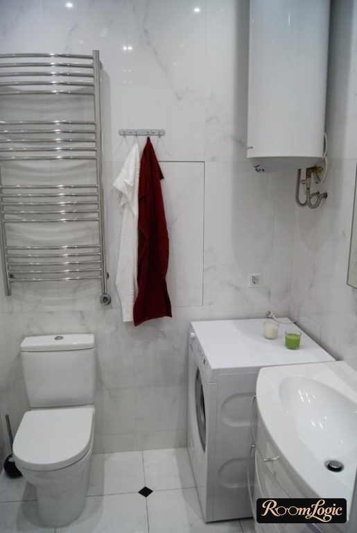 white bathroom with a water heater and washer