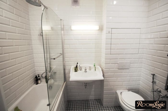 White cabinet in a small combined bathroom