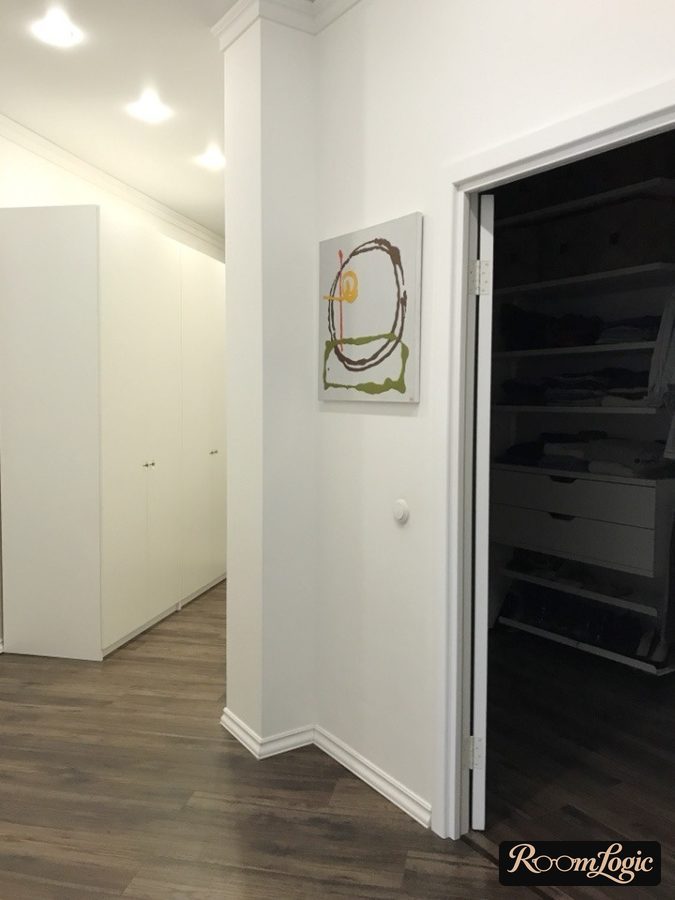 White cabinets and white walls and brown floor in the hallway