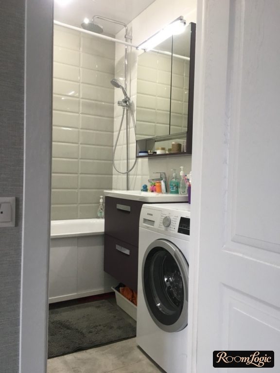 white glossy brick tiles in the bathroom of a tiny apartment with a washer