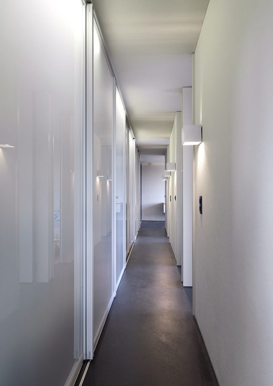 White glossy sliding-door wardrobe in hallway