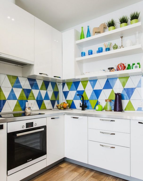 White kitchen in a tiny apartment with a colored backsplash made of tile