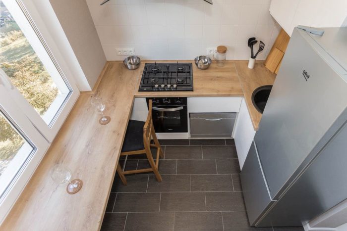 White kitchen in a tiny apartment with a wood-look countertop