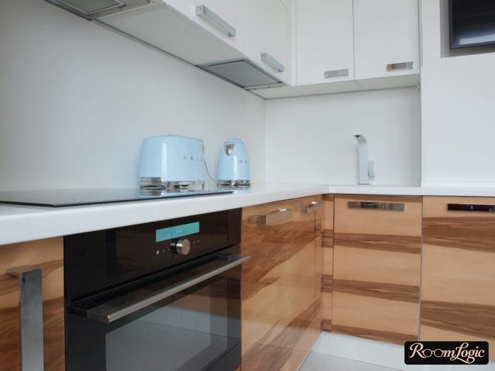 White kitchen with light glossy wood-look fronts on the lower cabinets