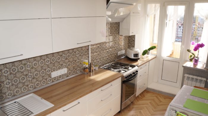 White kitchen with wooden countertop and pattern on the backsplash
