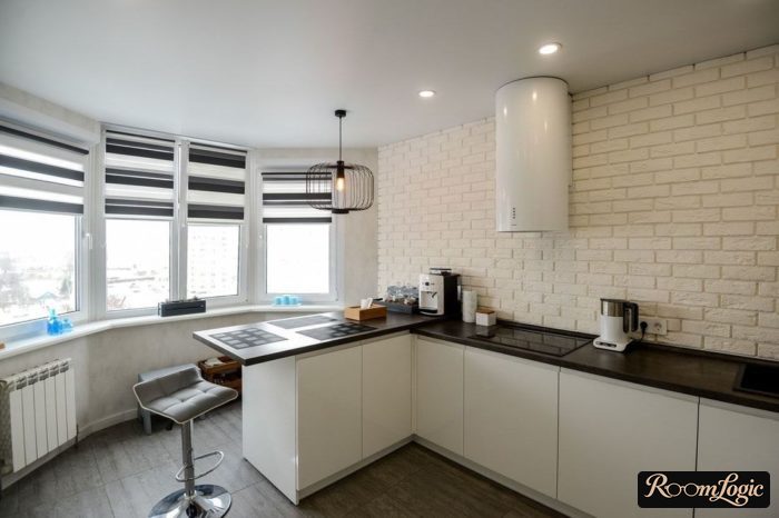 White kitchen without upper cabinets with black and white roller shades