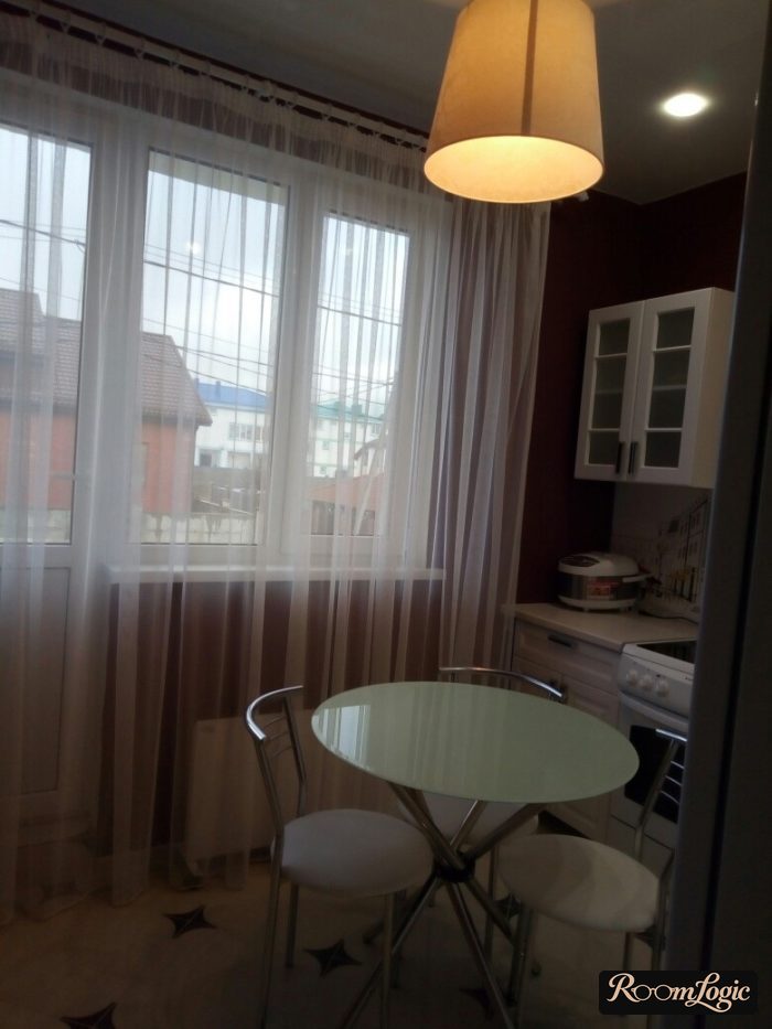 White sheer curtains in the kitchen-dining room with a balcony exit