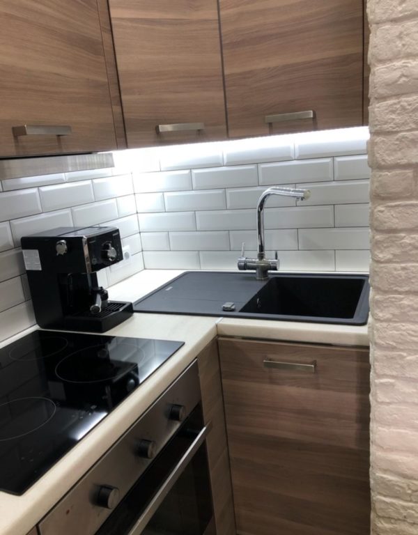 white subway tile on the backsplash of a small kitchen