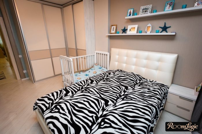 Zebra bedding and a corner wardrobe in a bedroom with a child's bed