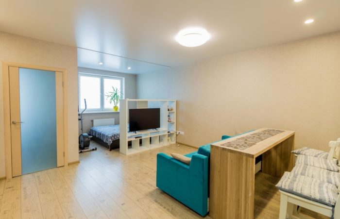 zoning of studio apartment with bed and sofa